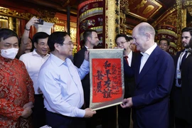 Thủ tướng Phạm Minh Chính tặng Thủ tướng Đức Olaf Scholz bức thư pháp với nội dung "Hòa bình - Hữu nghị cùng phát triển" tại đền Ngọc Sơn. (Ảnh: An Đăng/TTXVN)