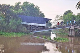 Nhịp giữa của cầu Xẻo Quýt lún sâu xuống nước. (Ảnh: TTXVN phát)