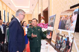 Thứ trưởng Bộ Quốc phòng Hoàng Xuân Chiến và Phó Tổng Thư ký Liên hợp quốc Jean-Pierre Lacroix cùng các đại biểu xem triển lãm ảnh về phụ nữ với hoạt động gìn giữ hòa bình LHQ. (Ảnh: Trọng Đức/TTXVN)