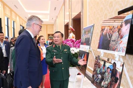 Thứ trưởng Bộ Quốc phòng Hoàng Xuân Chiến và Phó Tổng Thư ký Liên hợp quốc Jean-Pierre Lacroix cùng các đại biểu xem triển lãm ảnh về phụ nữ với hoạt động gìn giữ hòa bình LHQ. (Ảnh: Trọng Đức/TTXVN)