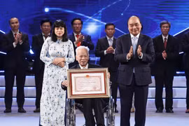 Chủ tịch nước Nguyễn Xuân Phúc trao Giải thưởng Hồ Chí Minh cho Giáo sư, Tiến sỹ khoa học Nguyễn Quang Hồng, tác giả công trình "Tự điển chữ Nôm dẫn giải". (Ảnh: Thống Nhất/TTXVN)