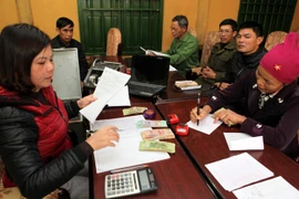 Các hộ gia đình vay vốn tại Ngân hàng Chính sách. (Nguồn: TTXVN)