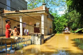 Nước ngập sâu nên người dân tại thôn Kiến Phong, xã Gia Tường, huyện Nho Quan, Ninh Bình phải di chuyển bằng thuyền. (Ảnh: Minh Đức/TTXVN)