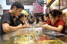 Khách hàng đang giao dịch vàng miếng. (Ảnh: TTXVN)
