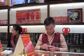 Nhân viên Bảo Tín Minh Châu kiểm tra vàng trang sức trước khi giao dịch với khách hàng. (Ảnh: Đức Duy/Vietnam+)