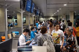 Hành khách làm thủ tục hàng không để lên chuyến bay. (Ảnh: CTV/Vietnam+)