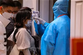 Đo thân nhiệt người dân nhằm phòng chống dịch bệnh COVID-19. (Ảnh: Sơn Bách/Vietnam+)