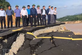 Lãnh đạo Bộ Giao thông vận tải và tỉnh Quảng Trị kiểm tra vị trí sạt lở trên đường Quốc lộ 9 do bão lũ ảnh hưởng. (Ảnh: Nguyên Lý/TTXVN)