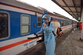 Tiến hành phun thuốc khử trùng đề phòng virus corona dọc đoàn tàu. (Ảnh: Việt Hùng/Vietnam+)