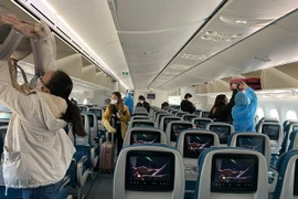 Hành khách trên một chuyến bay thực hiện nghiêm việc đeo khẩu trang theo đúng quy định. (Ảnh: CTV/Vietnam+)