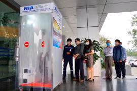 Nhân viên Cảng hàng không quốc tế Nội Bài đi qua buồng khử khuẩn toàn thân. (Ảnh: CTV/Vietnam+)