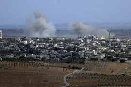 Khói bốc lên từ làng Jubata al-Khashab của Syria sau một vụ không kích của trực thăng quân sự ngày 13/10. (Nguồn: AFP/TTXVN)