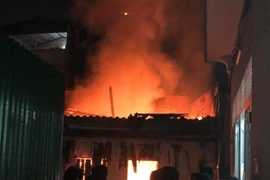 Hiện trường đám cháy lớn bùng phát khiến người dân xung quanh hoảng sợ. (Ảnh: TTXVN phát)