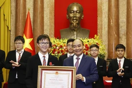 Chủ tịch nước Nguyễn Xuân Phúc trao tặng Huân chương Lao động hạng Nhì và hạng Ba cho các học sinh đoạt giải các cuộc thi Olympic và Khoa học kỹ thuật quốc tế năm 2022. (Ảnh: Thống Nhất/TTXVN) 
