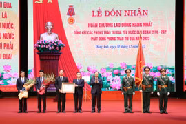 Thay mặt lãnh đạo Đảng, Nhà nước, Bí thư Thành ủy Hà Nội Đinh Tiến Dũng trao Huân chương Lao động hạng Nhất của Chủ tịch nước cho Đảng bộ và nhân dân huyện Đông Anh. (Ảnh: TTXVN phát)