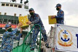 Các chiến sỹ chuyển hàng hóa, quà Tết lên tàu Trường Sa 19 để vận chuyển đến các nhà giàn DK1. (Ảnh: Thu Hiền/TTXVN) 