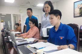 Phó Chủ tịch Ủy ban nhân Quận 3 Vũ Thị Mỹ Ngọc (giữa) kiểm tra, đôn đốc cán bộ nhân viên tăng cường thực hiện thẩm định hồ sơ theo Quyết định số 08/2022/QĐ-TTg. (Ảnh: Thanh Vũ/TTXVN)