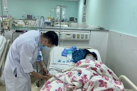 Bác sỹ Khoa hồi sức tích cực chống độc, bệnh viện Bà Rịa khám, điều trị cho bệnh nhân mắc sốt xuất huyết. (Ảnh: Hoàng Nhị/TTXVN)