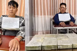 Hai đối tượng Vàng A Sồng (trái) và Hờ A Thu cùng 8 bánh heroin tại cơ quan điều tra. (Ảnh: TTXVN phát)
