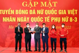 Đội tuyển nữ quốc gia tặng quả bóng có chữ ký của Ban huấn luyện và các cầu thủ cho Chủ tịch Quốc hội Vương Đình Huệ. (Ảnh: Phạm Kiên/TTXVN) 