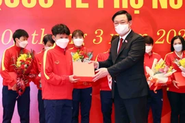 Chủ tịch Quốc hội Vương Đình Huệ tặng hoa và quà chúc mừng các nữ cầu thủ. (Ảnh: Phạm Kiên/TTXVN)