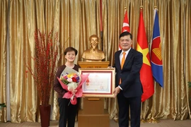 Đại sứ Mai Phước Dũng thay mặt Chủ tịch nước trao Huân chương hữu nghị cho bà Catherin Wong. (Ảnh: Lê Ngọc Dương/TTXVN)