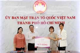 Ông Phạm Minh Tuấn, Phó Chủ tịch Ủy ban Mặt trận Tổ quốc Việt Nam Thành phố Hồ Chí Minh (thứ 2 từ trái sang) tiếp nhận tượng trưng số hàng hóa do đại diện Công ty Cổ phần Tập đoàn Yeah1 trao tặng. (Ảnh: Xuân Khu/TTXVN)