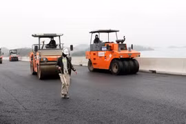 Trải thảm bêtông nhựa tuyến cao tốc Vân Đồn-Móng Cái. (Ảnh: Văn Đức/TTXVN)