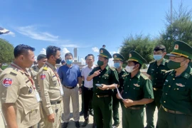 Cán bộ, chiến sỹ Đồn Biên phòng Cửa khẩu Quốc tế Tịnh Biên (Bộ đội Biên phòng tỉnh An Giang, Việt Nam) trao đổi các thủ tục pháp lý trước khi tiếp nhận 26 công dân Việt Nam do phía Campuchia trao trả. (Ảnh: Công Mạo/TTXVN)