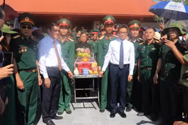 Nguyên Chủ tịch nước Trương Tấn Sang, Phó Thủ tướng Vũ Đức Đam cùng các đại biểu thực hiện nghi thức an táng hài cốt các liệt sỹ về với đồng đội. (Ảnh: Minh Tâm/TTXVN)