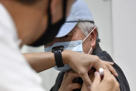 Nhân viên y tế Áo tiêm vaccine phòng COVID-19 cho người dân. (Ảnh: AFP/TTXVN)