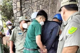 Lực lượng chức năng khống chế đối tượng và áp giải về trụ sở. (Ảnh: TTXVN phát)