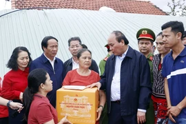 Chủ tịch nước Nguyễn Xuân Phúc và đoàn công tác tới thăm hỏi, động viên và tặng quà gia đình bà Đỗ Thị Thanh Hoa, ở thôn Thạch Nham Đông, xã Hòa Nhơn, huyện Hòa Vang, thành phố Đà Nẵng. (Ảnh: Thống Nhất/TTXVN) 