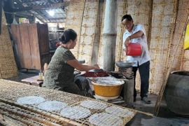 Bà Phan Thị Nhung và chồng là ông Phan Văn Hên, ngụ ấp An Lộc, xã An Ngãi, huyện Long Điền đang tráng bánh. Đây là nghề mà gia đình ông bà gắn bó 40 năm. (Ảnh: Hoàng Nhị/TTXVN)