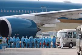 Các công dân xuống máy bay vào xe để về khu cách ly y tế. (Ảnh: Thành Đạt/TTXVN) 