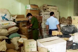 Lực lượng chức năng kiểm đếm số lượng thuốc bảo vệ thực vật hết hạn sử dụng vừa phát hiện. (Ảnh: TTXVN phát)