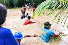 Lực lượng cứu hộ Philippines sơ tán người dân khỏi khu vực ngập lụt do mưa lớn gây ra bởi bão Nalgae ở Kalamansig, Sultan Kudarat, ngày 28/10/2022. (Ảnh: AFP/TTXVN)