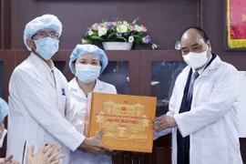 Chủ tịch nước Nguyễn Xuân Phúc tặng quà các y, bác sỹ tại Bệnh viện C Đà Nẵng. (Ảnh: Thống Nhất/TTXVN) 