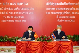 Bí thư Thành ủy Hà Nội Đinh Tiến Dũng và Bí thư Thành ủy Vientiane ký kết Biên bản hợp tác giữa hai thành phố Hà Nội và Vientiane. (Ảnh: Phạm Kiên/TTXVN)