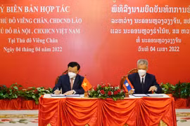 Bí thư Thành ủy Hà Nội Đinh Tiến Dũng và Bí thư Thành ủy Vientiane ký kết Biên bản hợp tác giữa hai thành phố Hà Nội và Vientiane. (Ảnh: Phạm Kiên/TTXVN)
