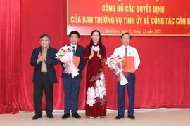 Ủy viên Trung ương Đảng, Bí thư Tỉnh ủy, Chủ tịch Hội đồng Nhân dân tỉnh Quảng Ngãi Bùi Thị Quỳnh Vân trao quyết định định và tặng hoa cho ông Lương Kim Sơn và Nguyễn Tưởng Duy. (Ảnh: TTXVN phát)