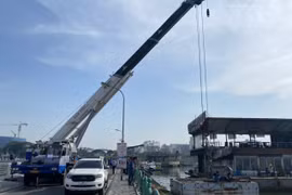 Sau khi tháo dỡ, phương tiện nổi được cẩu lên để đưa về nơi tập kết theo quy định. (Ảnh: TTXVN phát)