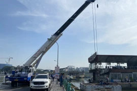 Sau khi tháo dỡ, phương tiện nổi được cẩu lên để đưa về nơi tập kết theo quy định. (Ảnh: TTXVN phát)