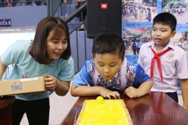 Nhân viên Mạng lưới tự kỷ Việt Nam hướng dẫn trẻ tự kỷ tham gia các trò chơi thực hành hòa nhập cộng đồng tại Ngày hội tri ân giáo viên trẻ tự kỷ (16/11/2019). (Ảnh: Thanh Vũ/TTXVN) 