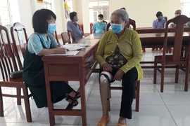 Phan Bích Ngân (trái) hỗ trợ hội viên Hội Phụ nữ khuyết tật thành phố Cần Thơ các vấn đề về pháp lý. (Ảnh: TTXVN phát)