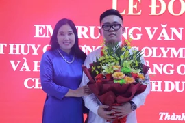 Niềm vui của em Trương Văn Quốc Bảo và cô giáo Cao Thị Lan Thanh trở về từ cuộc thi Olympic Tin học quốc tế tại trường THPT Chuyên Phan Bội Châu. (Ảnh: Bích Huệ/TTXVN)