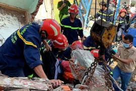 Lực lượng cảnh sát cứu một nạn nhân khỏi bức tường đổ sập. (Ảnh: Thành Chung/TTXVN) 