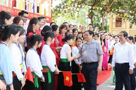 Thủ tướng Phạm Minh Chính với giáo viên, học sinh Trường trung học phổ thông Yên Lập, huyện Yên Lập. (Ảnh: Dương Giang/TTXVN)