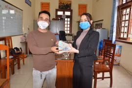 Anh Bùi Văn Trọng trao trả lại tài sản cho chị Vũ Thị Thùy Năng. (Ảnh: TTXVN phát)