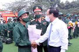 Ông Nguyễn Văn Nên, Ủy viên Bộ Chính trị, Bí thư Thành ủy Thành phố Hồ Chí Minh tặng hoa, động viên các thanh niên lên đường thực hiện nghĩa vụ quân sự tại điểm giao-nhận quân Quận 12, Thành phố Hồ Chí Minh. (Ảnh: Xuân Khu/TTXVN)